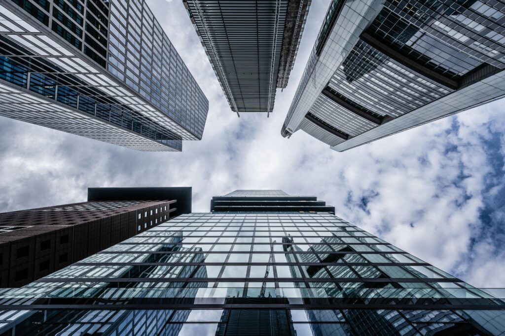 A striking upward view of modern skyscrapers in Frankfurt showcasing architectural elegance against a cloudy sky.